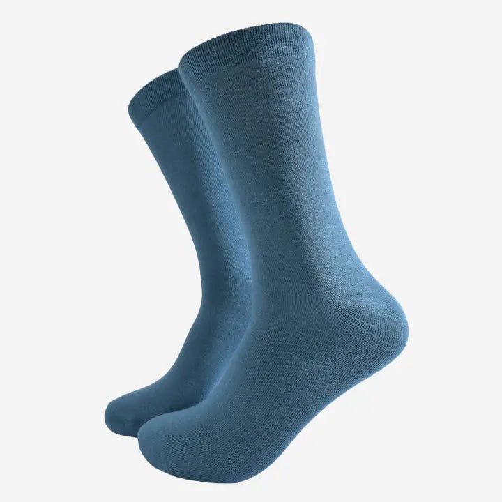 Black bamboo dress socks for men displayed on wooden surface, breathable eco-friendly footwear gift UK sizes 7–11.